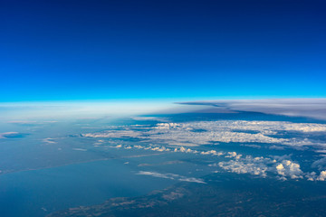Fototapeta na wymiar Clouds, earth, sky view from plane window in sunny day.