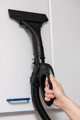 hand with a steam gun to clean and disinfect furniture as a prevention of the Covid-19