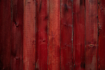 Aged red wooden wall with cracks and scuffs