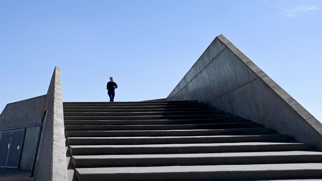 Attractive young woman, running down stairs in slow motion, stock footage by Brian Holm Nielsen