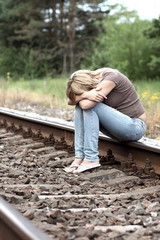 Upset girl sitting on the rails