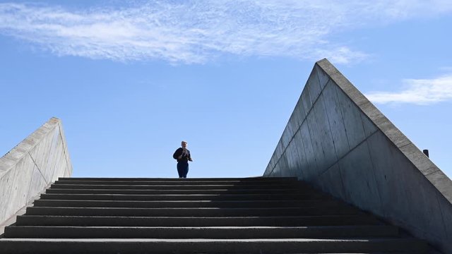 Attractive young woman, running down stairs in slow motion, stock footage by Brian Holm Nielsen