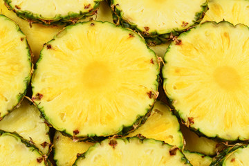 Pineapple juicy yellow slices background. Top view.