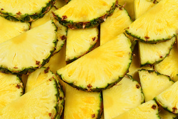 Pineapple juicy yellow slices background. Top view.
