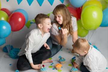 Fototapeta na wymiar mother with two sons rides a festive cupcake. child's birthday