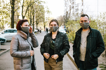Fototapeta premium Family(mother, father, daughter) in protective mask from coronavirus in the street 