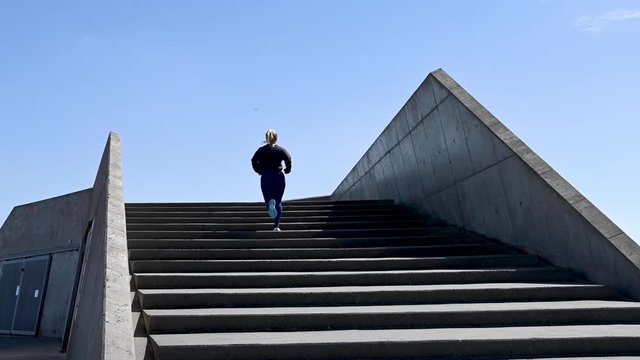 Attractive young woman, running up stairs, stock footage by Brian Holm Nielsen