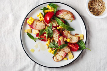 Salad with grilled peaches, corn, fresh tomatoes and basil.