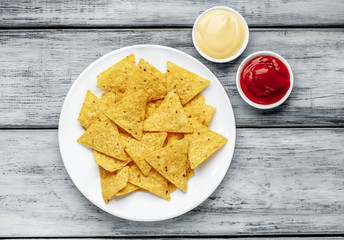 Mexican nachos chips in a white plate on a wood background
