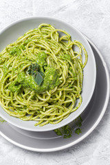 Spaghetti with homemade pesto sauce on gray background