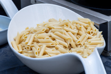 Chef preparing pasta boiling pasta and cooking. Food catering live cooking station during reception