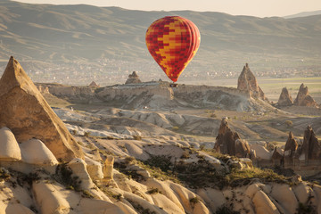 Balloon over Valleys of Cappadocia in background, aerial view