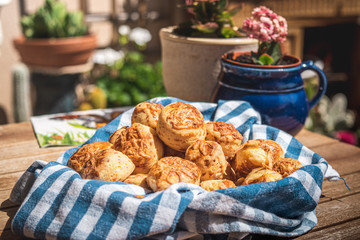 Homemade aperitif cake served in the traditional way with a blue checkered tablecloth blurred background with flowers