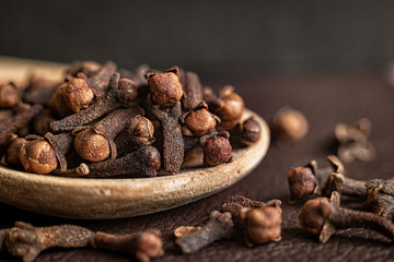 Spice clove in a wooden spoon, close up.