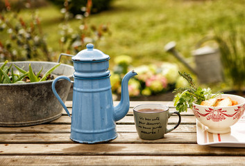 Tea from vintage teapot, pour into mug. Provence.