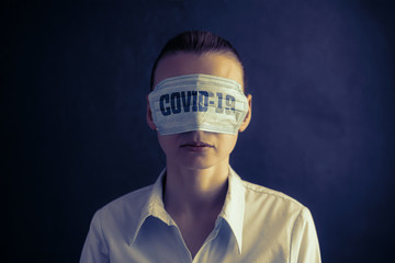 woman with medical face mask, dressed in eyes. concept of conspiracy, deception and misinformation...