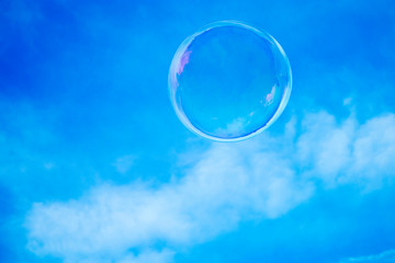 Soap sparkling bubble against a blue sky.