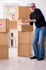 Old male professional mover doing home relocation