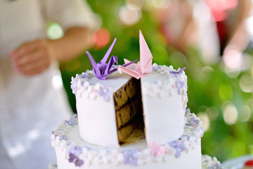 Smash cake with cream on the outside and chocolate on the inside at a wedding with a couple of paper birds..