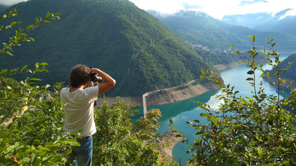 Young man make photo of Piva Lake, Montenegro.