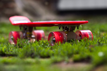 red children's skateboard in the grass