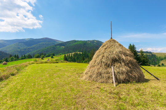 idyllic rural landscape on a sunny summer day. idyllic rural. hay stack on the field. wonderful countryside in mountains beneath a blue sky with fluffy clouds