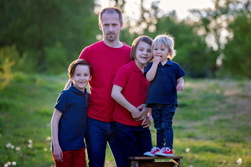 Spring portrait of happy family in nature on sunset