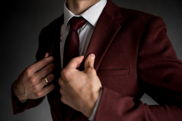man in a burgundy tuxedo on a gray background