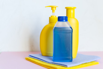 Household chemicals on white background. Professional cleaning products, spring cleaning.yellow and blue plastic containers for household detergents, home chemistry.cleaning supplies.Copy space