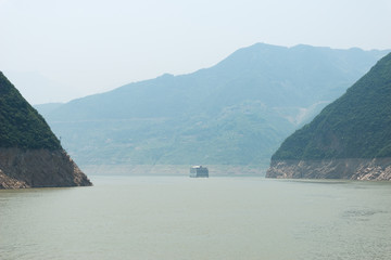 China, Chongqing, Flusskreuzfahrt auf dem Yangtze Fluss, Blick durch die Qutang-Schlucht auf ein Schiff in der Ferne auf dem Yangtze Fluss.