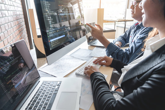 Programmers cooperating at Developing programming and website working in a software develop company office, writing codes and typing data code, Programming with HTML, PHP and javascript