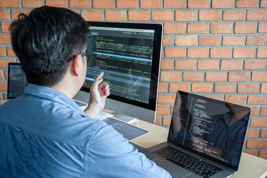 Young Professional programmer working at developing programming and website working in a software develop company office, writing codes and typing data code, Programming with HTML, PHP and javascript