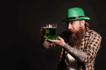 Bearded man with green beer on black background, space for text. St. Patrick's Day celebration