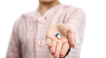 Child holds in the palm a pills.