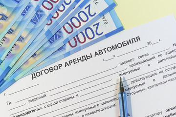 Obraz premium The signing of a bilateral agreement of renting a car from an individual. Russian roubles, the handle and the text 