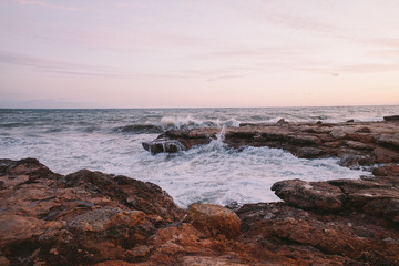 Fototapeta na wymiar Sunrise on a rocky beach in Apulia, Italy