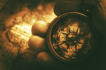 Golden Compass Hand And Map Close Up. - Powered by Adobe