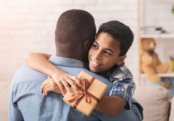 Happy Black Boy Hugging Dad And Giving Him Gift Box