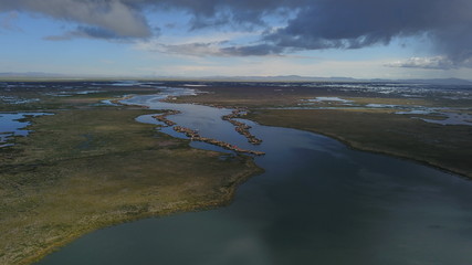 Lake Titicaca in Puno in Peru, view from drone and floating islands of the Uros people in the background