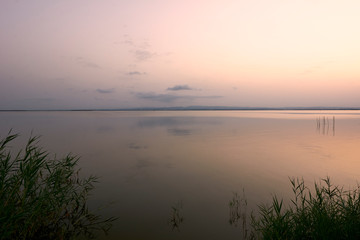 Sunset on the big lake, from the reeds, green, golden colors, calm waters, reflections