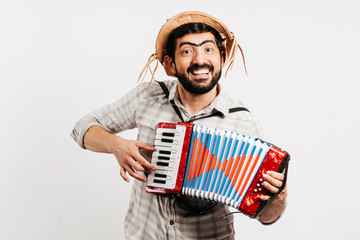 Brazilian man wearing traditional clothes for Festa Junina - June festival - playing toy accordion