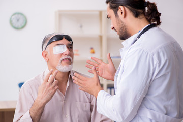 Old blind man visiting young male doctor