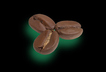Three roasted coffee beans on a black background