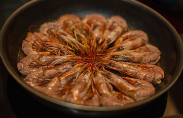 the process of cooking shrimps at home, fry shrimps in a pan, shrimps are fried on the stove (close up)