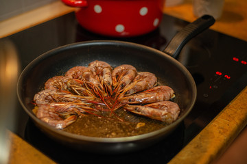 the process of cooking shrimps at home, fry shrimps in a pan, shrimps are fried on the stove