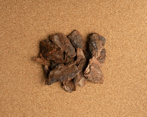 Fototapeta na wymiar Heap of Pine Tree Bark Chip on Brown Cork Board Background