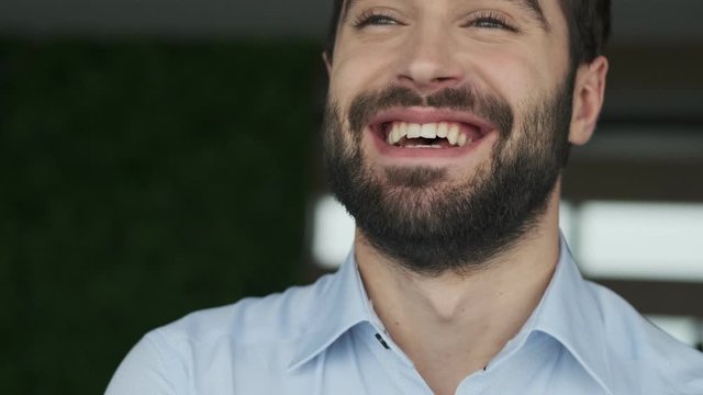 Handsome positive optimistic young business man indoors in office