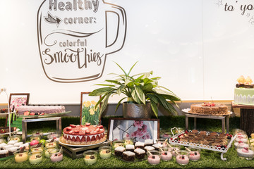 Large assortment of desserts, muffins, cakes, tarts. Candy bar wedding reception brunch buffet