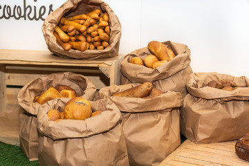 Selection of Fresh baked bread baskets and paper bags with bread roasted in the oven, croissants