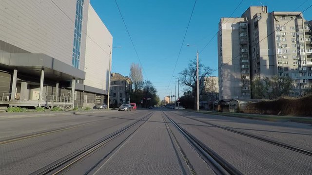 empty street with rails for trams, sparsely populated, quarantine, self-isolation, warm spring day, clear sky, virus epidemic forces people to be at home